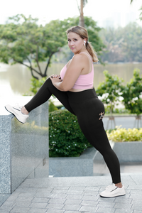 curvy-woman-stretching-her-legs-while-wearing-leggings-wiith-tiny-flat-man-on-butt-pink-top